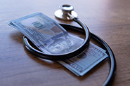stethoscope wrapped around a stack of U.S. dollar bills